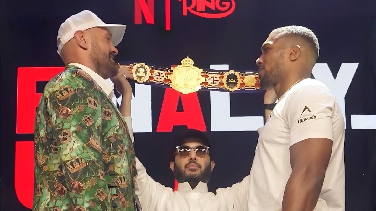 Tyson Fury and Anthony Joshua face off with a championship belt held between them at their press conference